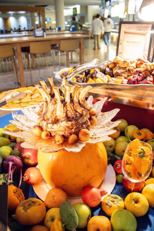 a table with decorated pumpkins and dinner dishes